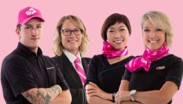 WestJet Breast Cancer Awareness Month Ambassadors Rudy, Carey, Cat, and Lynn in their custom-designed pink-neckwear, hat and pink ‘personality’ pins